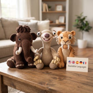 Può includere: Tre animali di peluche realizzati all'uncinetto tra cui un mammut marrone scuro, un bradipo marrone chiaro con grandi occhi e una tigre arancione con zanne bianche. Un cartoncino bianco riporta il testo Available Languages e cinque icone di bandiere.