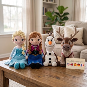 May include: Four crocheted dolls featuring a blonde character in a light blue dress, a brown-haired character in a blue and magenta outfit, a white snowman, and a brown reindeer. A card displays the text "Available Languages" with five flag icons.