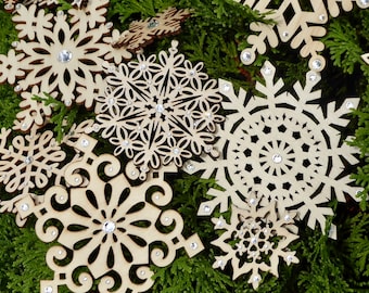 Set of fourteen assorted wood snowflakes hand decorated with sparkling glass crystals, various sizes and patterns