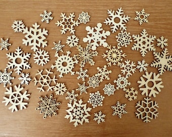 Mixed lot 36 laser cut wood snowflakes ranging in size from 1 to 2 3/8 inches.