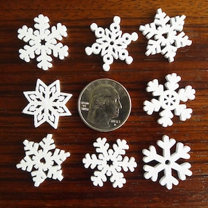 Twenty 25mm, or 1 inch, white laser cut wood snowflakes