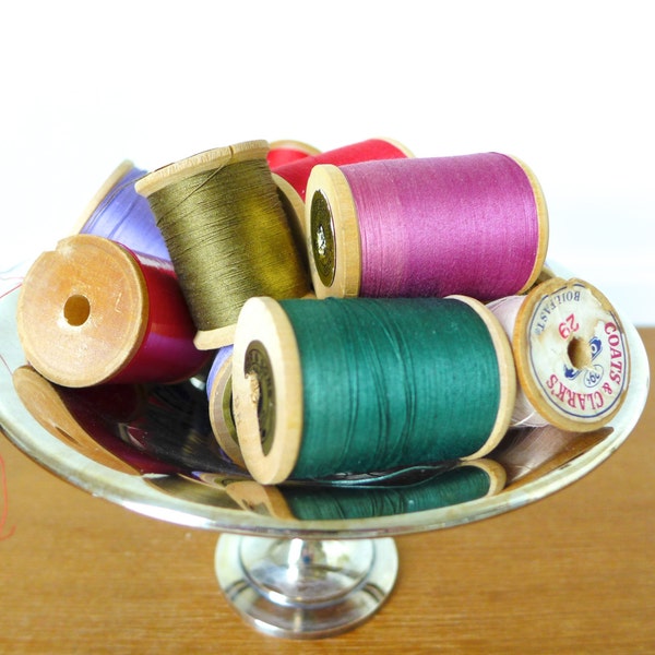 Fourteen large wooden spools with thread