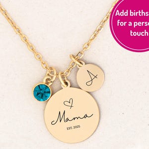 May include: Gold-colored necklace with a pendant that says "Mama" and a small heart. It has a teal-colored gemstone and a small disc with the letter "A". The text "EST. 2025" is below "Mama".