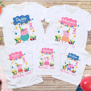 Pode incluir: Cinco camisetas brancas com personagens da Peppa Pig, gráficos coloridos de festa de aniversário e texto incluindo Daddy of the 3, Mommy of the 3, Sister of the 3, Brother of the 3 e Ashley Birthday Girl com um número 3 grande.