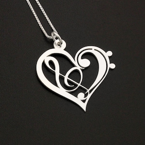 May include: A silver necklace with a heart-shaped pendant featuring a treble clef and musical notes.