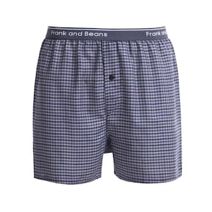 Puede incluir: Calzoncillos tipo bóxer con estampado de cuadros vichy en azul y negro. La prenda tiene una cintura elástica azul oscuro con el texto blanco Frank and Beans impreso repetidamente. Un botón oscuro está centrado en la parte superior de la bragueta.