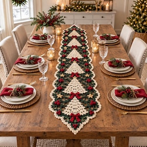 Pode incluir: Um longo caminho de mesa em crochê com um padrão repetitivo de árvores de Natal cor de creme sobre um fundo verde escuro, acentuado com pequenos laços vermelhos, bagas vermelhas e estrelas douradas, centrado numa mesa de jantar de madeira.