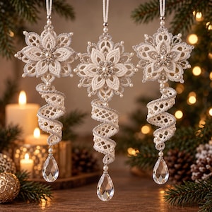 May include: Three hanging ornaments featuring cream-colored lace star-shaped tops with silver metallic thread accents and small white pearls. Each ornament has a spiraling lace tail ending in a clear, faceted, teardrop-shaped crystal pendant.