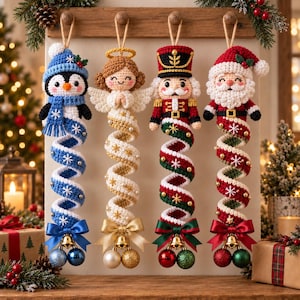 Pode incluir: Quatro enfeites de Natal em crochê pendurados num suporte de madeira. As figuras incluem um pinguim com gorro azul, um anjo com auréola dourada, um quebra-nozes e o Pai Natal. Cada um tem uma longa cauda em espiral decorada com contas.