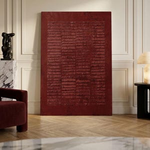 May include: A large rectangular wall art piece in a deep, dark red hue. The surface features a textured, relief-style pattern consisting of numerous horizontal, stacked rectangular segments that create a rhythmic, grid-like visual composition.