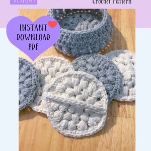 以下が含まれることがあります： 手作りのかぎ針編みフェイシャルスクラビーと、それに合うホルダーの写真。スクラビーはグレーとクリーム色で、質感のある円形デザインです。画像には「Face Scrubbies Crochet Pattern」というテキストも含まれています。