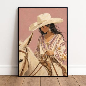 May include: A framed wall art print featuring a person wearing a wide-brimmed cream cowboy hat and a long-sleeved white blouse with purple and orange floral patterns. The person is riding a white donkey with a brown leather bridle and saddle.