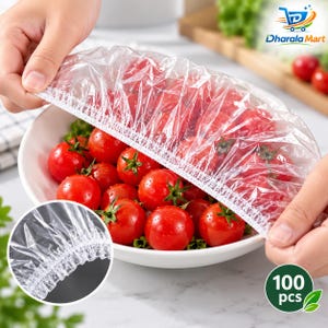 May include: A clear, elasticized plastic food cover with a white stitched edge, designed to stretch over bowls. The cover is shown placed over a white bowl filled with fresh red cherry tomatoes, featuring a gathered, pleated rim for a secure fit.