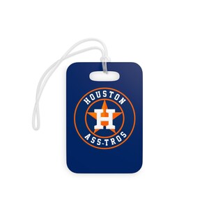 Puede incluir: Una etiqueta de equipaje rectangular de color azul marino con el logotipo de los Houston Astros en el centro. El logo consiste en una letra H blanca sobre una estrella naranja, encerrada en un círculo naranja con el texto HOUSTON ASTROS.