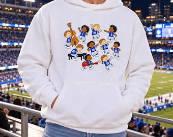 May include: A white hooded sweatshirt featuring a graphic print of cartoon characters wearing blue and white football jerseys. The characters are depicted playing various musical instruments, including a double bass, a piano, and a red electric guitar.