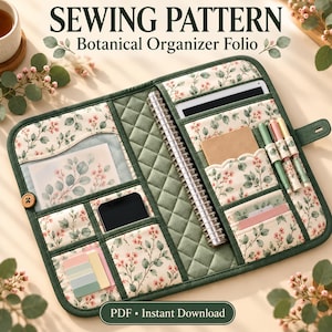 May include: A quilted fabric organizer folio featuring a botanical print of green leaves and small pink flowers. The interior includes multiple pockets, a spiral-bound notebook, a smartphone, pens, and sticky notes. Text reads SEWING PATTERN.