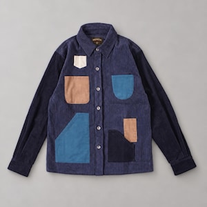Può includere: Una camicia in velluto a coste blu navy con abbottonatura, colletto, maniche lunghe e diverse tasche asimmetriche color crema, marrone chiaro, azzurro e blu scuro. L'etichetta interna riporta la scritta Threadfolk.