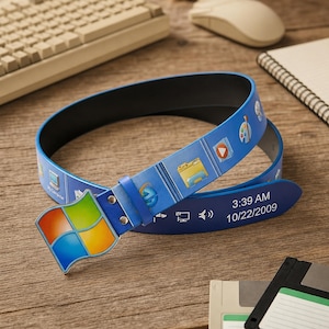 May include: A blue belt featuring a colorful four-pane window logo buckle. The strap displays various computer desktop icons and a taskbar print with the text 3:39 AM and 10/22/2009. The belt has a black interior lining and silver metal rivets.