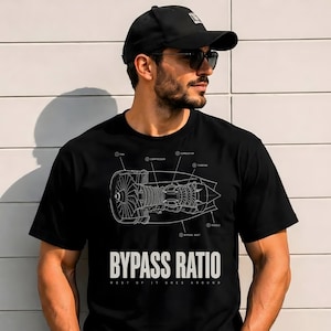 Pode incluir: Uma t-shirt preta com um diagrama de linhas brancas de um motor a jato com componentes rotulados, incluindo ventoinha, compressor, combustor, turbina, bocal e duto de derivação. O texto BYPASS RATIO está impresso em letras brancas.