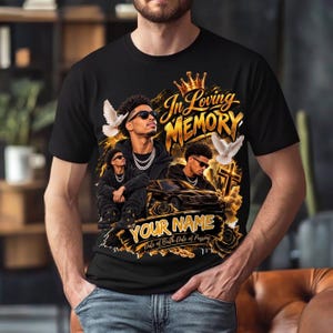May include: A black t-shirt featuring a memorial graphic with the text In Loving Memory, Your Name, and Date of Birth-Date of Passing. The design includes two images of a person wearing sunglasses, a gold crown, white doves, a car, and a cross.