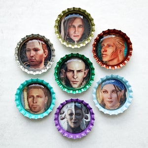 May include: Seven bottle caps with images of characters from a video game. The caps are in various colors, including silver, gold, red, green, teal, purple, and blue. The images are portraits of people.