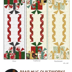 May include: Three Fa La La table runners by Bear Hug Quiltworks, measuring 18 inches by 54 inches. The designs include Silver, Traditional, and Parchment colorways, each featuring a central zigzag pattern flanked by gift box motifs with holiday imagery.