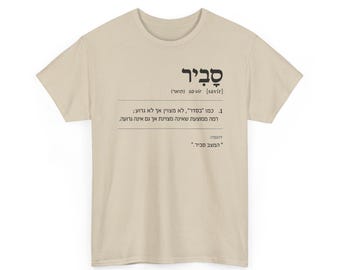 May include: A beige short-sleeved t-shirt featuring black Hebrew text printed on the front. The text displays the word "סביר" followed by a phonetic pronunciation, a dictionary-style definition, and an example sentence in Hebrew.