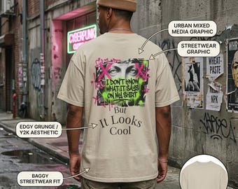 May include: A beige short-sleeve t-shirt featuring a back graphic with a pair of eyes, pink spray-painted X marks, and green splatters. The text reads: I DON'T KNOW WHAT IT SAYS ON MY SHIRT But It Looks Cool. The front of the shirt is plain beige.