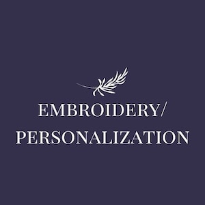 May include: White text on a dark blue background reads "Embroidery/Personalization" with a small white stylized leaf design above the text.