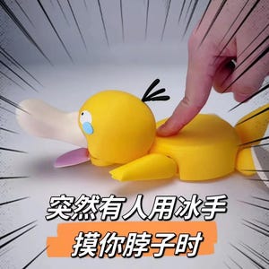 Op de afbeelding: Een geel eendachtig figuurtje met een brede crèmekleurige snavel, een paarse tong en drie zwarte haarlokken op het hoofd. Het figuurtje heeft een wit oog met daaronder een blauwe traanvorm. Chinese tekst is onder het figuurtje weergegeven.