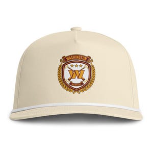 May include: A cream-colored baseball cap featuring a white cord trim along the base of the crown. The front displays a crest with the text WASHINGTON, three stars, a large letter W, two crossed rifles, and the Roman numeral MCMXXXII in gold and maroon.