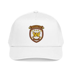 May include: A white baseball cap featuring a centered embroidered crest. The crest displays the text WASHINGTON in a banner, three stars, a large yellow W, crossed batons, and the Roman numeral MCMXXXII on a shield with maroon borders.