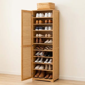 May include: A tall, light-toned bamboo shoe cabinet featuring ten horizontal shelves filled with various styles of footwear, including sneakers, boots, and flats. The cabinet has a single hinged door with a vertical slatted panel design.