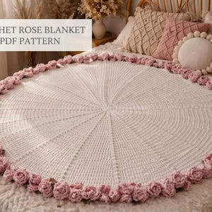 May include: A circular white crochet blanket featuring a border of three-dimensional pink roses. The center of the blanket has a radiating stitch pattern. The text CROCHET ROSE BLANKET PDF PATTERN is visible in the upper left corner of the image.