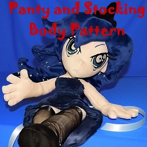 May include: A blue plush toy with black hair and a black dress. The toy is wearing black stockings and has a blue ribbon around its leg. The text "Sample of Completed Plush" is visible in the image.