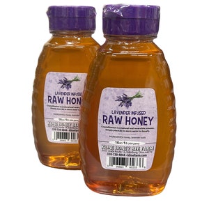May include: Two 16 ounce bottles of raw honey infused with lavender. The bottles have purple lids and labels that say "Lavender Infused Raw Honey". The labels also include the ingredients, honey and lavender buds, and the company name, Kline Honey Bee Farm.