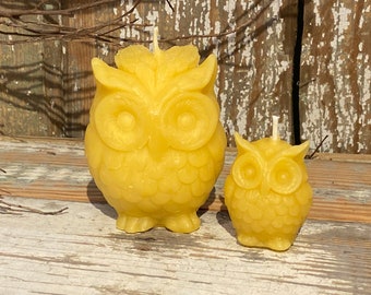 May include: Two yellow beeswax candles shaped like owls. The larger owl is about 4 inches tall and the smaller owl is about 2 inches tall.