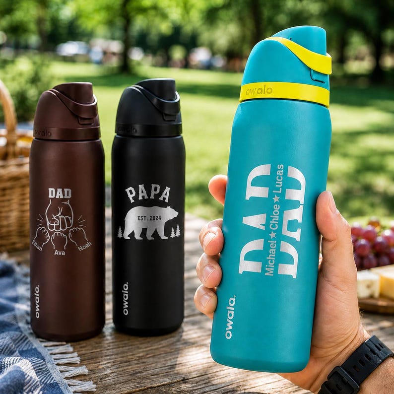 May include: Three insulated water bottles with personalised text. One brown bottle says "DAD" with a fist graphic and names. A black bottle says "PAPA" with a bear graphic. A teal bottle says "DAD" with names.