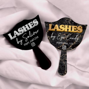 May include: Two black and white eyelash fan mirrors with gold lettering. The top mirror says "Lashes by Soliver" with the Instagram handle "@get_nail1234". The bottom mirror says "Lashes by Eye Candy" with the Instagram handle "@getlashes_123".