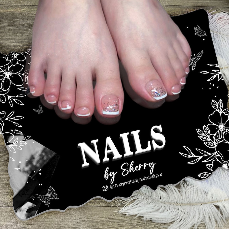 Puede incluir: Primer plano de dedos de los pies con pedicura, puntas francesas y detalles de purpurina. Las u&ntilde;as est&aacute;n sobre una superficie decorativa negra con el texto "NAILS by Sherry" en blanco. Dise&ntilde;os florales y de mariposas en los bordes.