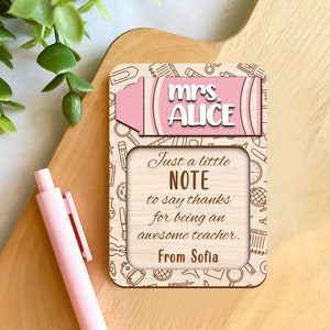 May include: A wooden teacher appreciation plaque with the name "Mrs. Alice" and the message "Just a little NOTE to say thanks for being an awesome teacher. From Sofia." The plaque has a pink and white crayon design and school-themed illustrations.