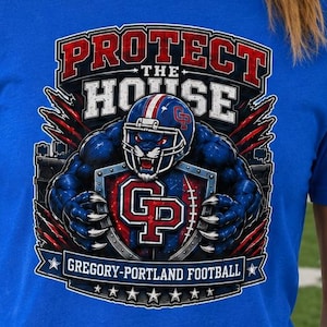 Könnte beinhalten: Ein königsblaues Kurzarm-T-Shirt mit einem Grafikdruck, der den Text PROTECT THE HOUSE und GREGORY-PORTLAND FOOTBALL zeigt. Das Design umfasst einen Panther mit Football-Helm, einen Schild mit den Buchstaben GP sowie rote und weiße Akzente.