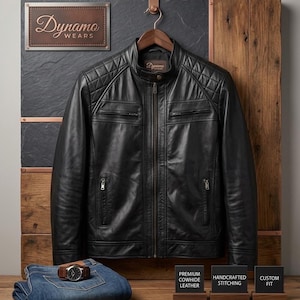 May include: A black leather jacket with a mandarin collar, quilted shoulder panels, and a central zip closure. The jacket features two zipped chest pockets and two lower zipped pockets. A pair of blue jeans and a wristwatch are also present.