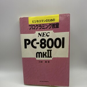 May include: A book with a textured mauve cover featuring a yellow banner at the top with Japanese text. The center displays the text NEC PC-8001 mkII in bold black letters, with additional Japanese text at the bottom and author name.