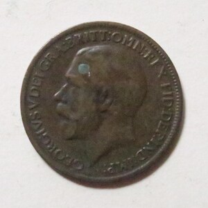 May include: A copper-colored coin with the profile of a man on one side. The coin has the words "GEORGIVS V DEI GRA REX ET IMP" around the edge.