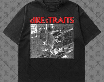 May include: A black short-sleeve t-shirt featuring the red text "DIRE STRAITS" above a white graphic print. The graphic depicts a high-contrast, grainy black and white image of a pair of shoes resting on a metal surface with a textured background.