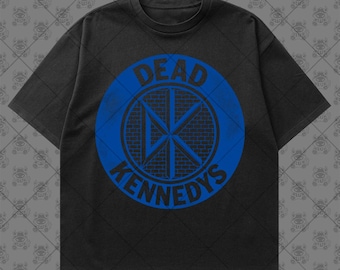 May include: A black short-sleeve t-shirt featuring a large blue circular graphic on the chest. The graphic contains a brick-patterned background with the letters DK in the center and the text DEAD KENNEDYS arched around the top and bottom.