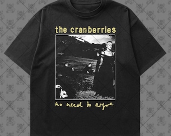 May include: A black short-sleeve t-shirt featuring a graphic print of The Cranberries album cover. The print includes the text "the cranberries" in yellow at the top and "no need to argue" in yellow at the bottom, surrounding a black and white photograph.