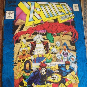 May include: A comic book cover featuring a group of superheroes in a futuristic setting. The cover is blue and features a red monster with wings, a white superhero with a beard, a green superhero, a female superhero with blue hair, a male superhero with red hair, and a female superhero with black hair. The comic book is titled "X-Men 2099" and is issue number 1.