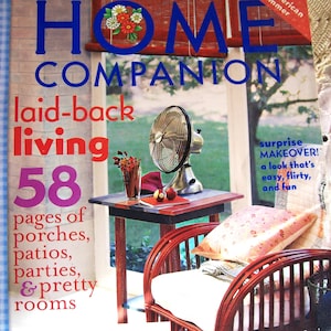 May include: A magazine cover for "Home Companion" with the title in blue letters. The cover features a small table with a fan, a red chair with a white cushion, and the text "laid-back living". The magazine is dated June/July 2004.